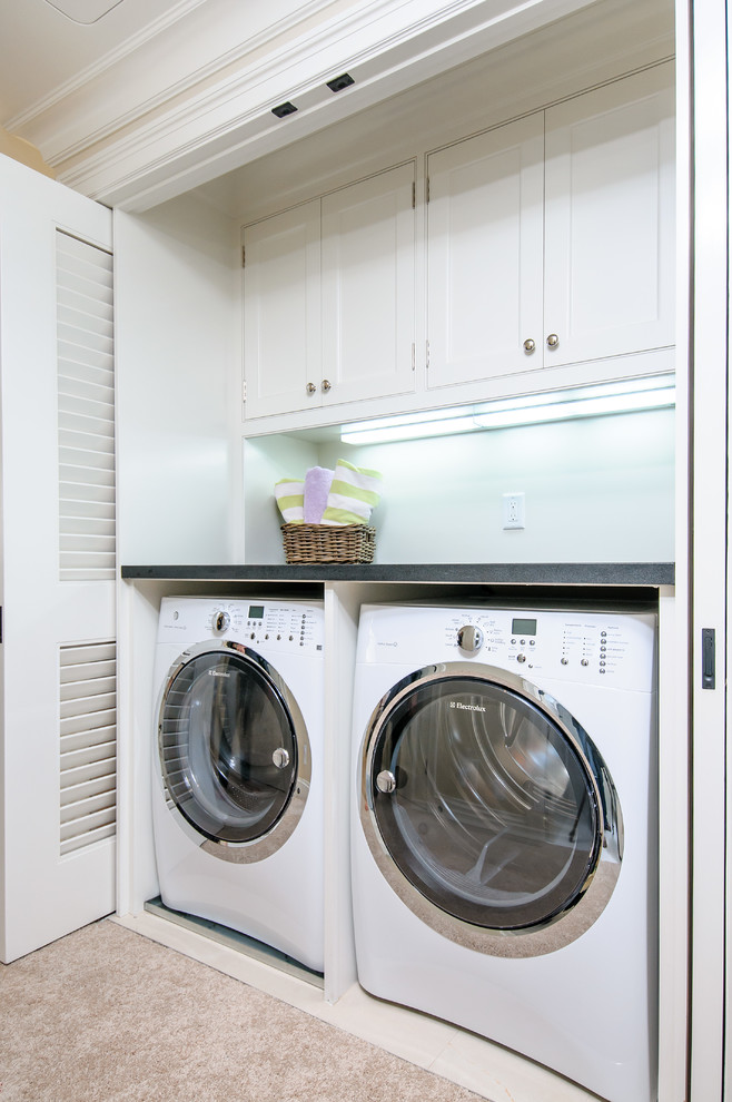 Diseño de armario lavadero lineal tradicional renovado con armarios con paneles lisos, puertas de armario blancas, encimera de mármol, lavadora y secadora juntas y paredes blancas