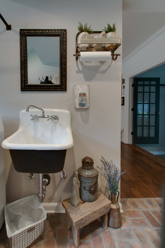 Utility room - small cottage brick floor and multicolored floor utility room idea in Nashville with a farmhouse sink, shaker cabinets, brown cabinets, granite countertops, gray walls, a side-by-side washer/dryer and black countertops