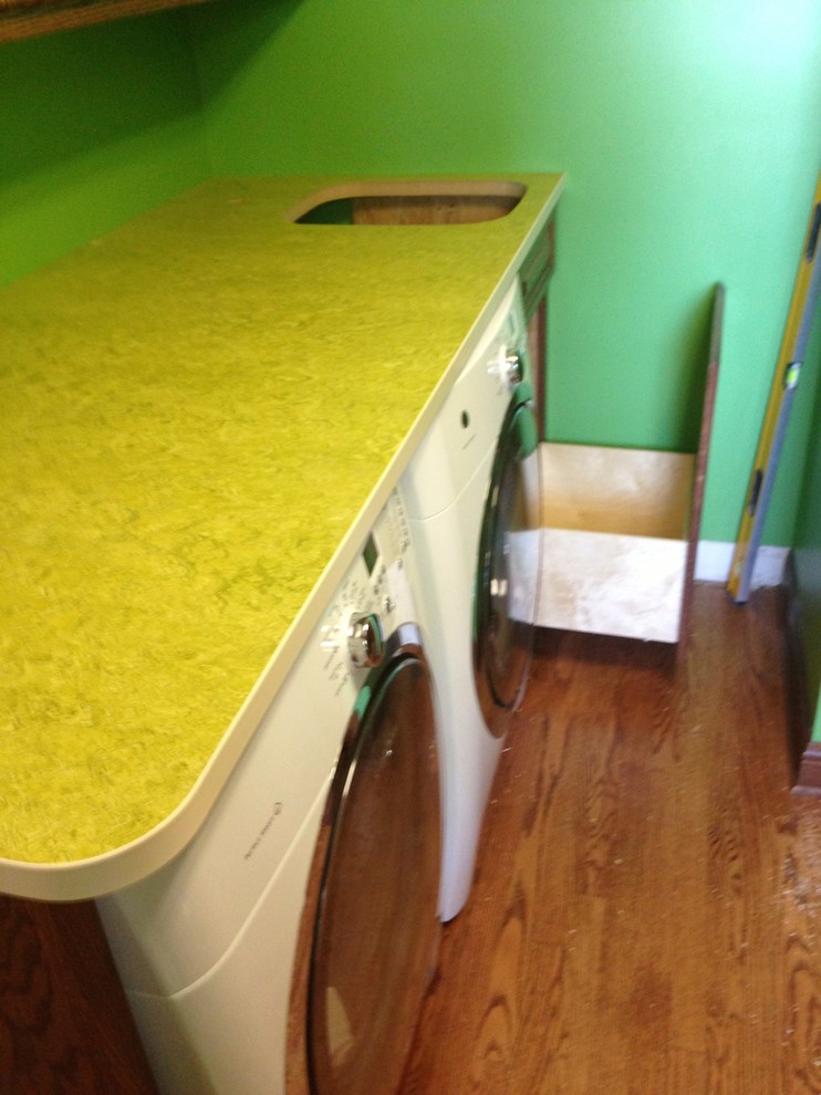 Foto di una lavanderia con lavello da incasso, ante in legno scuro e top verde