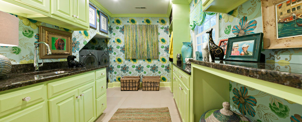 Idee per una grande sala lavanderia minimal con lavello sottopiano, ante con bugna sagomata, ante verdi, top in granito, pareti multicolore, pavimento con piastrelle in ceramica e lavatrice e asciugatrice affiancate