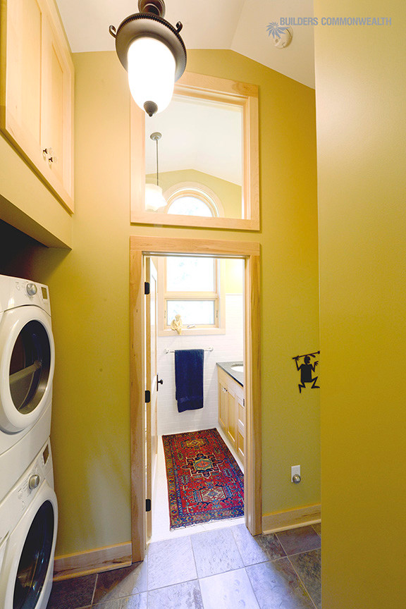 Immagine di una lavanderia multiuso classica con ante in stile shaker, ante in legno chiaro, pareti verdi e lavatrice e asciugatrice a colonna