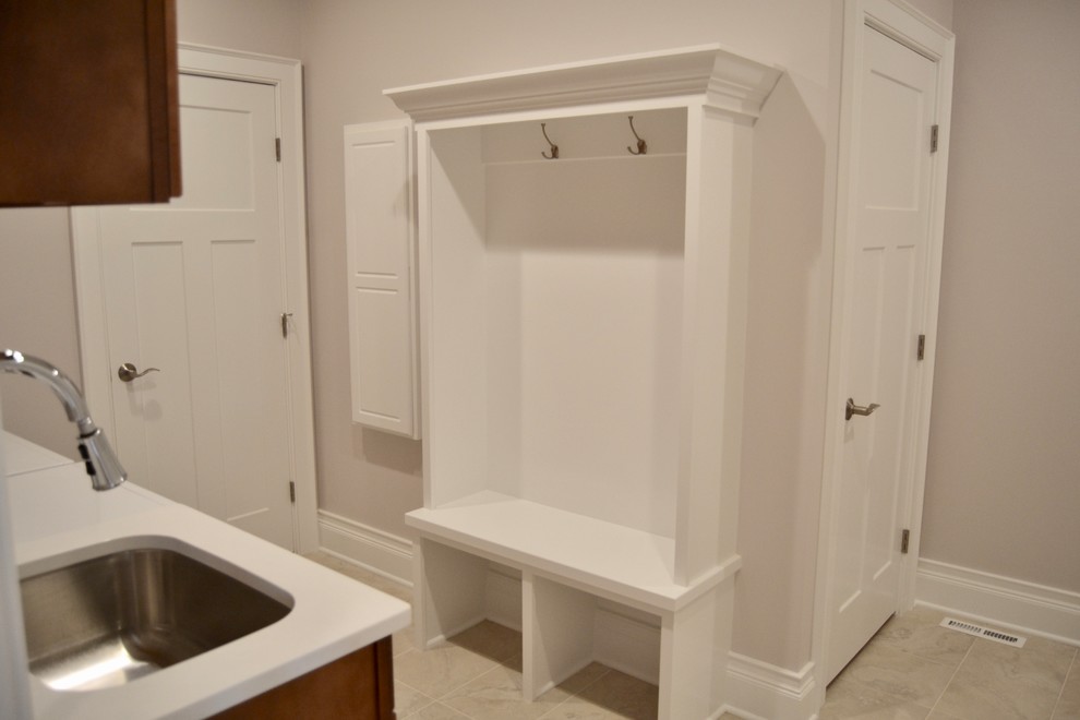 Photo of a medium sized classic utility room in New York with shaker cabinets, grey walls, ceramic flooring and grey floors.