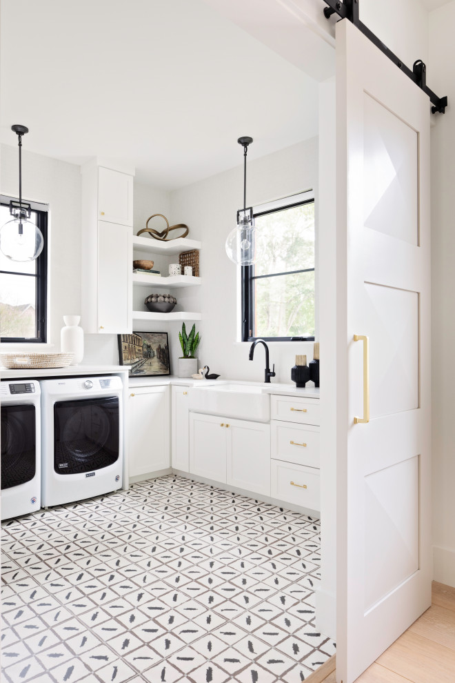 Exempel på en stor klassisk vita u-formad vitt tvättstuga enbart för tvätt, med en rustik diskho, skåp i shakerstil, vita väggar, klinkergolv i keramik, en tvättmaskin och torktumlare bredvid varandra, vita skåp och flerfärgat golv
