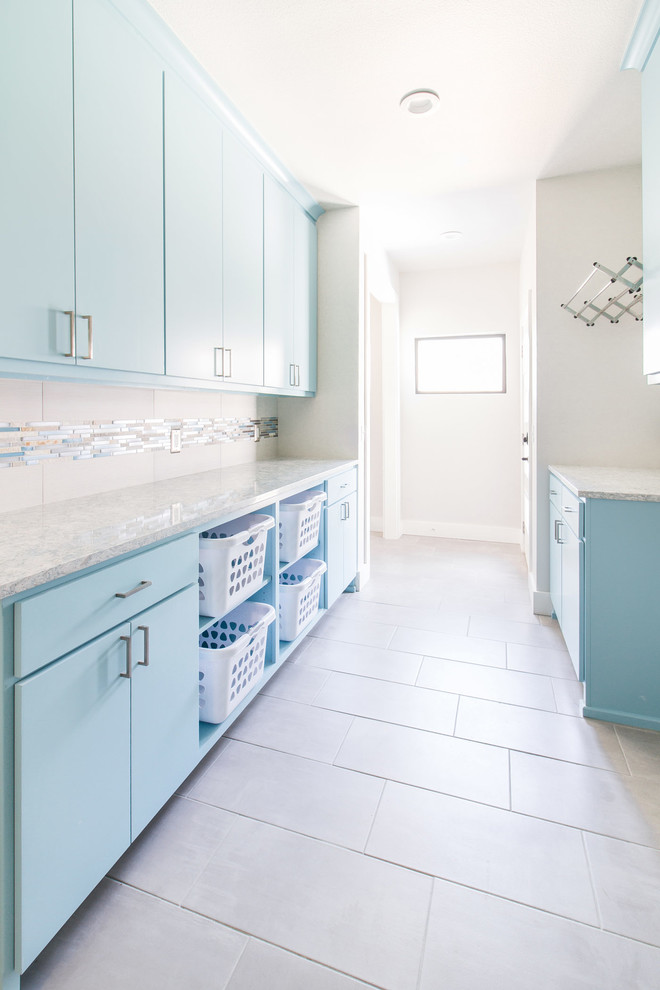 Design ideas for a galley separated utility room in Other with flat-panel cabinets, blue cabinets, granite worktops, grey walls, porcelain flooring, grey floors and grey worktops.