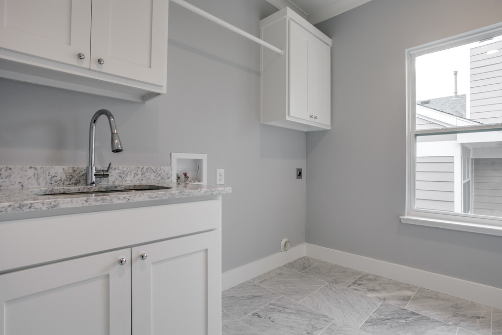 Idéer för en mellanstor amerikansk linjär tvättstuga enbart för tvätt, med en undermonterad diskho, skåp i shakerstil, vita skåp, marmorbänkskiva, grå väggar, marmorgolv och en tvättmaskin och torktumlare bredvid varandra