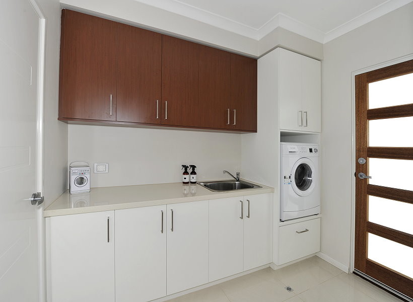 Einzeilige, Kleine Moderne Waschküche mit Ausgussbecken, flächenbündigen Schrankfronten, weißen Schränken, weißer Wandfarbe, weißem Boden und Waschmaschine und Trockner integriert in Perth