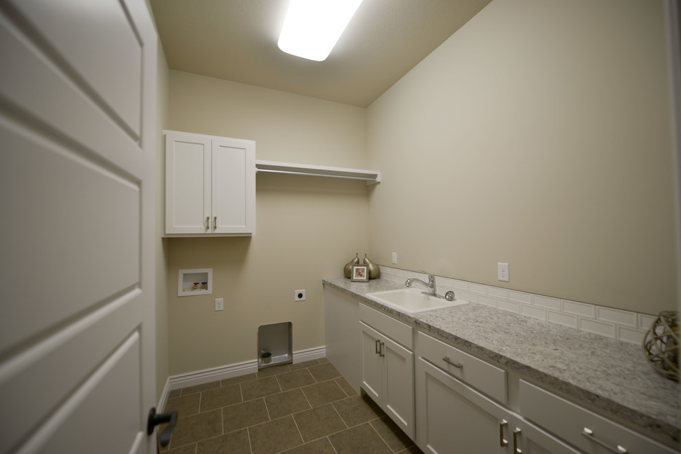 Inspiration for a large contemporary l-shaped ceramic tile laundry room remodel in Wichita with a drop-in sink, white cabinets, granite countertops, beige walls and a side-by-side washer/dryer