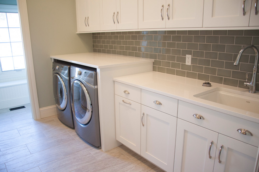 Utility room - mid-sized modern single-wall porcelain tile and beige floor utility room idea in St Louis with an undermount sink, shaker cabinets, white cabinets, solid surface countertops, gray walls and a side-by-side washer/dryer