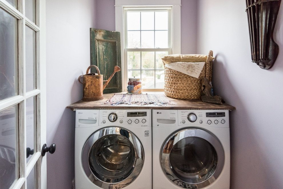 Immagine di una piccola sala lavanderia country con top in legno, pareti viola e lavatrice e asciugatrice affiancate