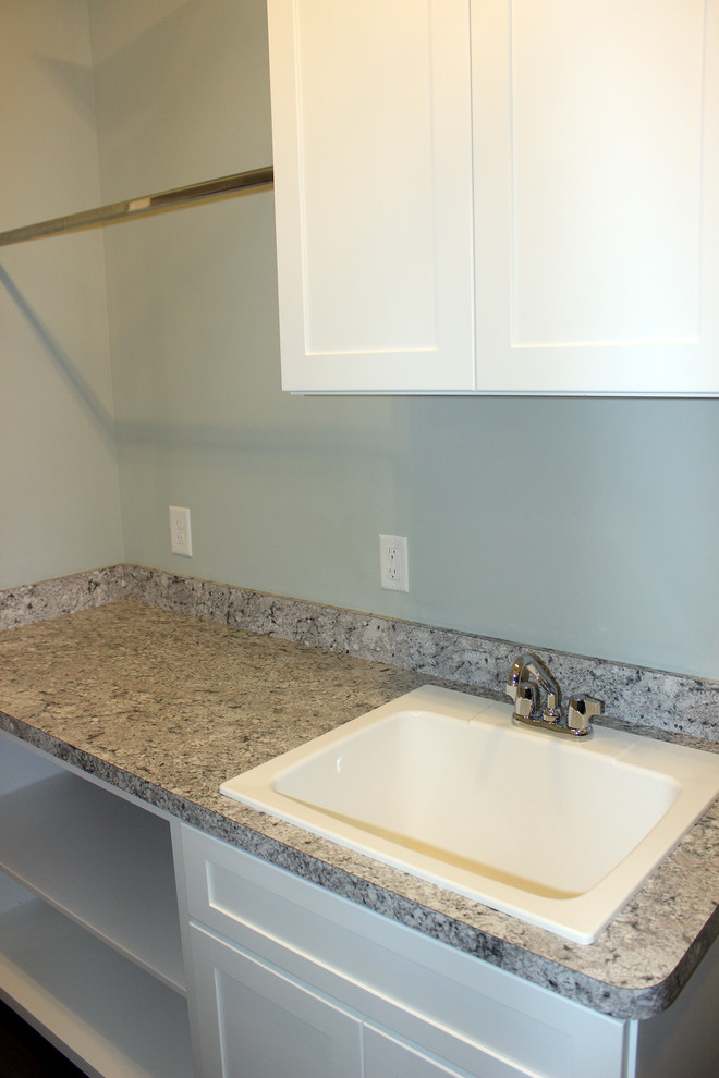 Inspiration for a small beach style single-wall separated utility room in Cleveland with a built-in sink, shaker cabinets, white cabinets, laminate countertops, blue walls and grey worktops.