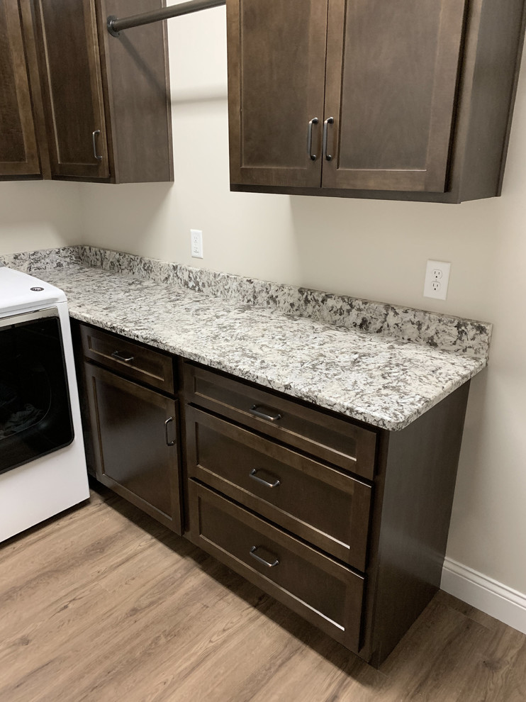 Example of a transitional l-shaped laminate floor and beige floor dedicated laundry room design in Other with shaker cabinets, dark wood cabinets, granite countertops, a side-by-side washer/dryer, multicolored countertops and beige walls