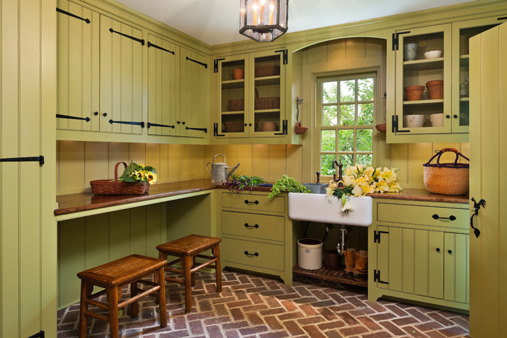 フィラデルフィアにあるトラディショナルスタイルのおしゃれな家事室 (L型、エプロンフロントシンク、緑のキャビネット、木材カウンター) の写真