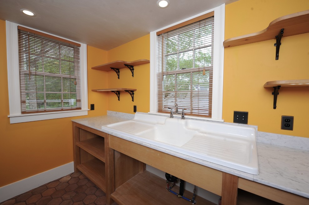 Exempel på en eklektisk tvättstuga, med en allbänk, öppna hyllor, marmorbänkskiva, orange väggar och klinkergolv i terrakotta