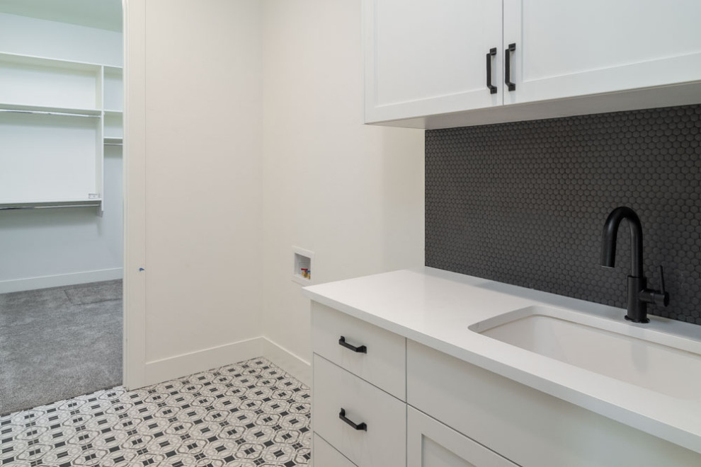 This is an example of a medium sized traditional utility room in Boise with a submerged sink, shaker cabinets, white cabinets, composite countertops, white walls, vinyl flooring, multi-coloured floors and white worktops.
