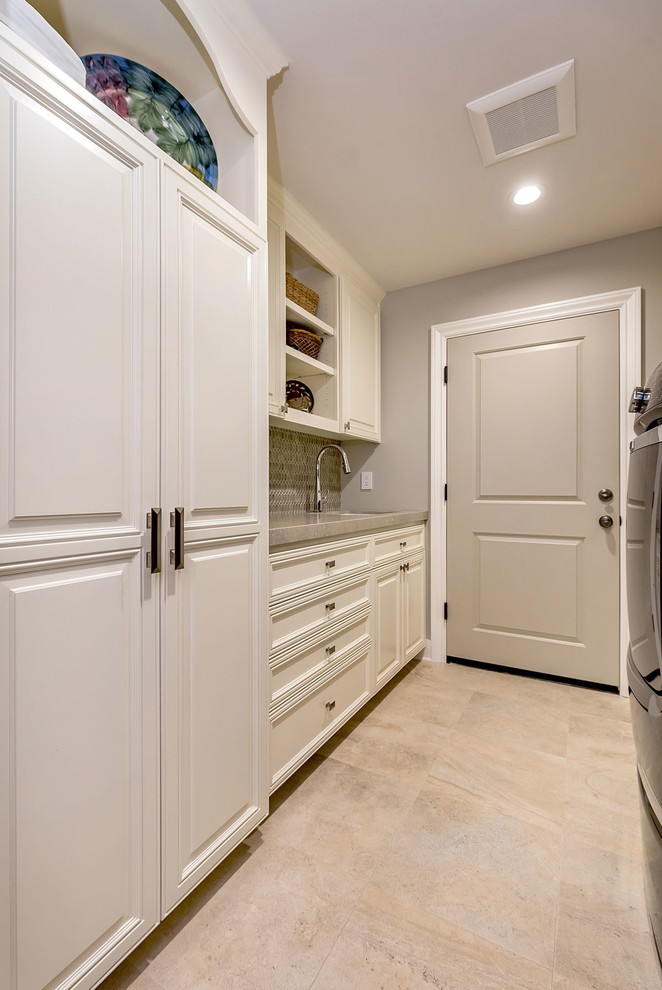Inspiration for a mid-sized contemporary galley ceramic tile dedicated laundry room remodel in San Francisco with an undermount sink, raised-panel cabinets, white cabinets, limestone countertops, gray walls and a side-by-side washer/dryer