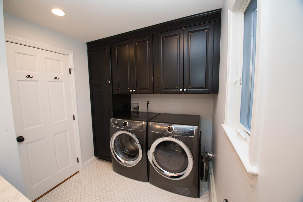 Modelo de lavadero clásico renovado pequeño con puertas de armario negras, suelo de baldosas de porcelana, suelo blanco y armarios con paneles con relieve
