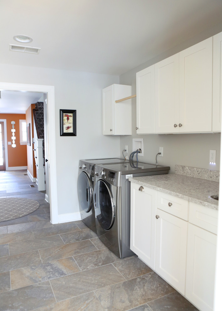 Idéer för en stor klassisk parallell tvättstuga enbart för tvätt, med en undermonterad diskho, skåp i shakerstil, vita skåp, laminatbänkskiva, grå väggar, skiffergolv, en tvättmaskin och torktumlare bredvid varandra och grått golv