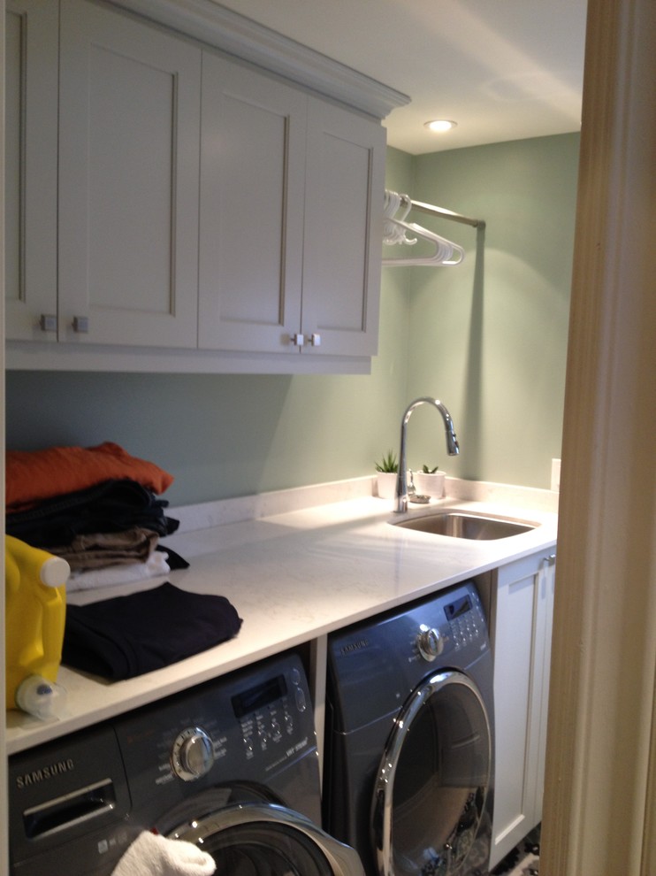 Small traditional single-wall separated utility room in Toronto with a submerged sink, recessed-panel cabinets, grey cabinets, engineered stone countertops, green walls, porcelain flooring and a side by side washer and dryer.