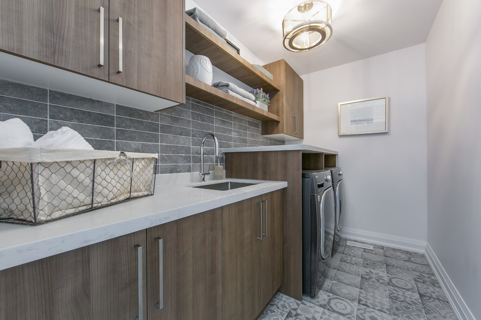 This is an example of a medium sized contemporary single-wall separated utility room in Toronto with a submerged sink, flat-panel cabinets, medium wood cabinets, marble worktops, grey walls, porcelain flooring, a side by side washer and dryer, grey floors and white worktops.