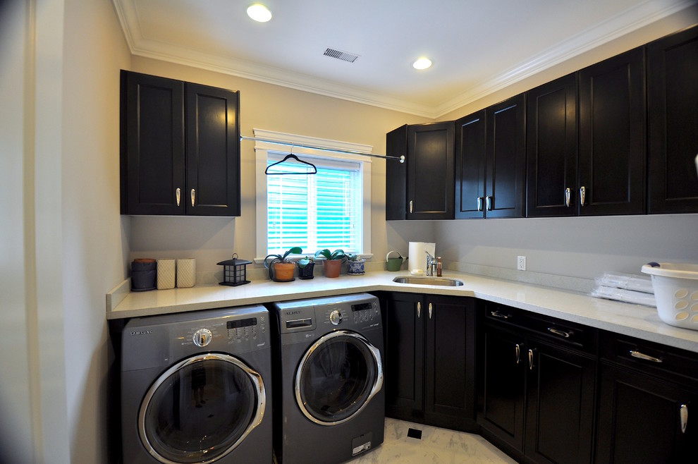 Esempio di una grande sala lavanderia con lavello sottopiano, ante in stile shaker, ante nere, pareti bianche, lavatrice e asciugatrice affiancate e pavimento multicolore