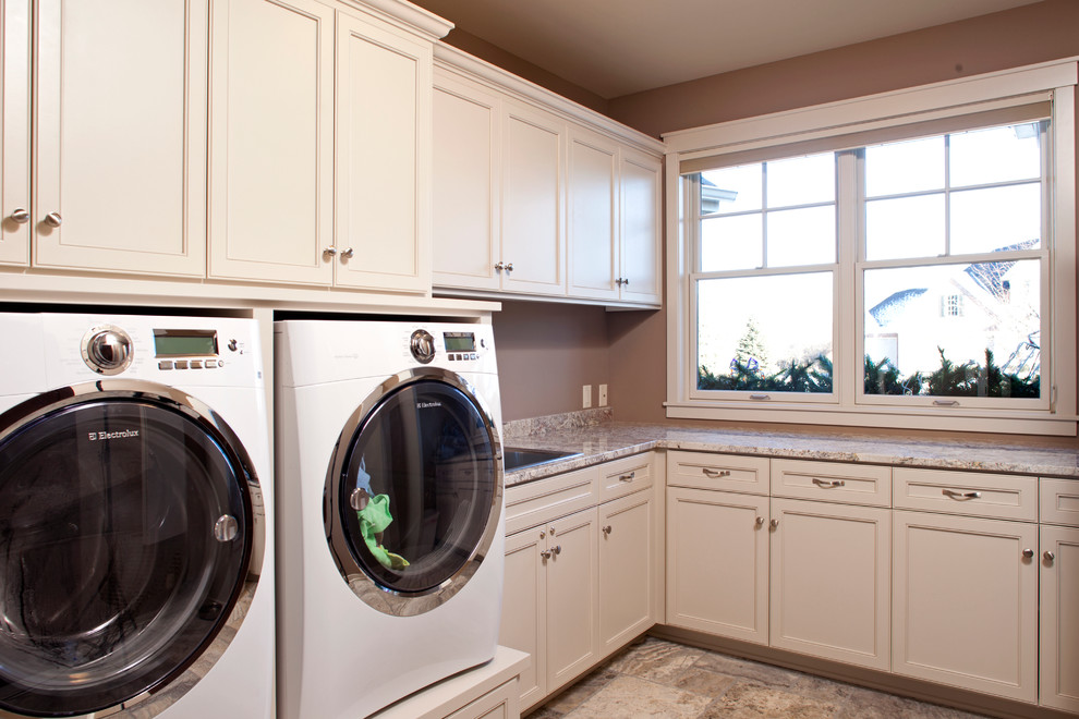 Große Klassische Waschküche in L-Form mit Einbauwaschbecken, Schrankfronten mit vertiefter Füllung, weißen Schränken, Granit-Arbeitsplatte, beiger Wandfarbe und Waschmaschine und Trockner nebeneinander in Minneapolis