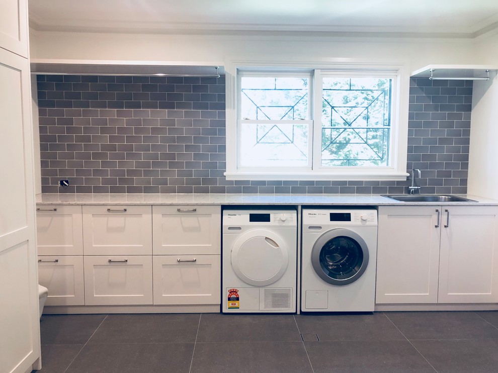 Inspiration for a huge transitional u-shaped porcelain tile and gray floor dedicated laundry room remodel in Sydney with a drop-in sink, shaker cabinets, white cabinets, quartz countertops, white walls and a side-by-side washer/dryer