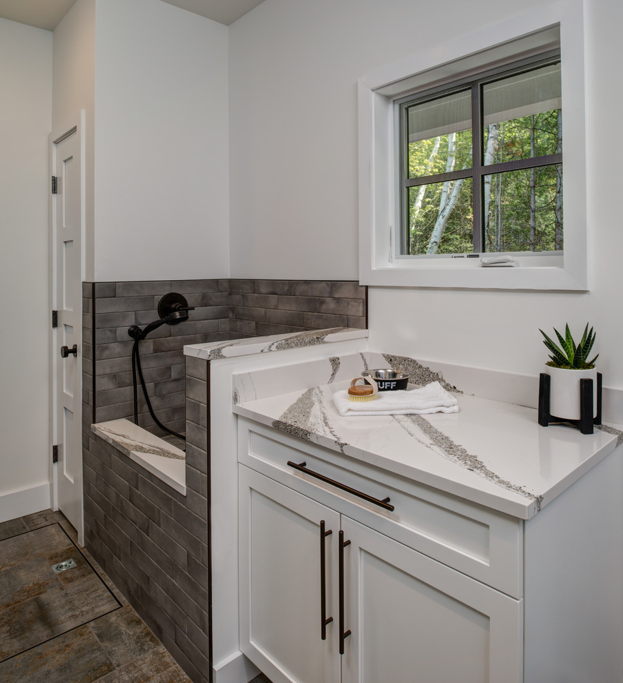 This is an example of a classic utility room in Other with shaker cabinets, white cabinets, engineered stone countertops, a side by side washer and dryer, grey floors and white worktops.
