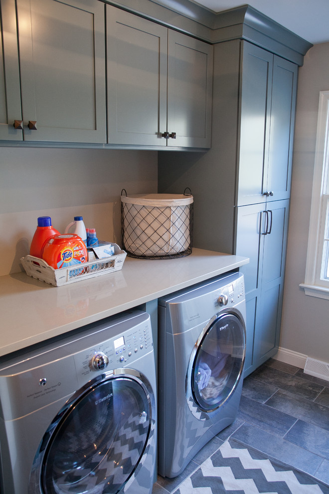 Idee per una piccola lavanderia multiuso tradizionale con pareti grigie, pavimento in ardesia, ante in stile shaker, ante blu, top in quarzo composito e lavatrice e asciugatrice affiancate