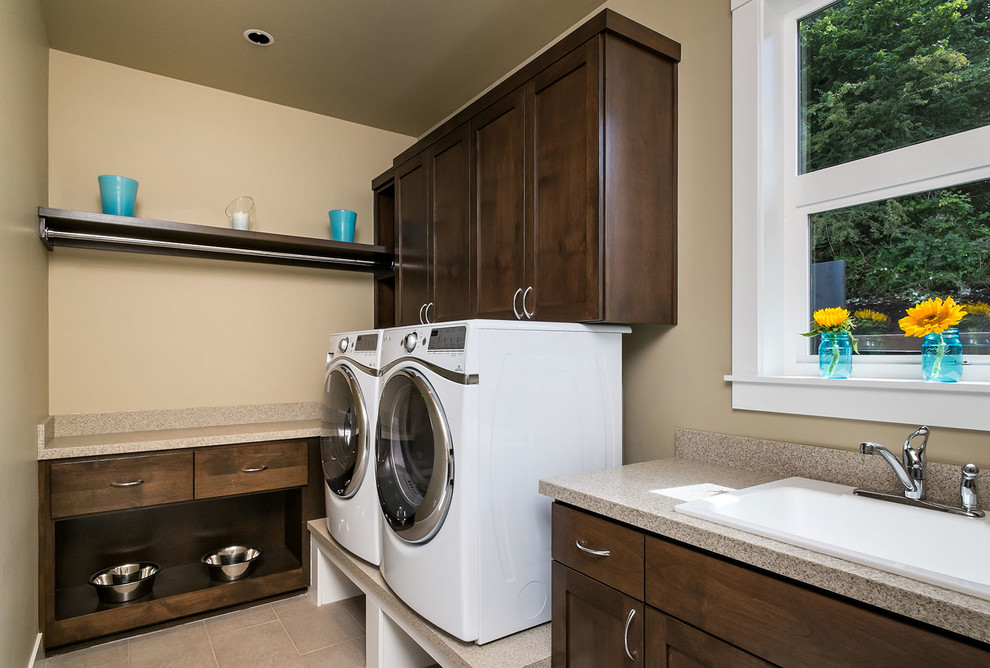 Inspiration for a large modern separated utility room in Portland with a built-in sink, shaker cabinets, dark wood cabinets, engineered stone countertops, beige walls, porcelain flooring and a side by side washer and dryer.