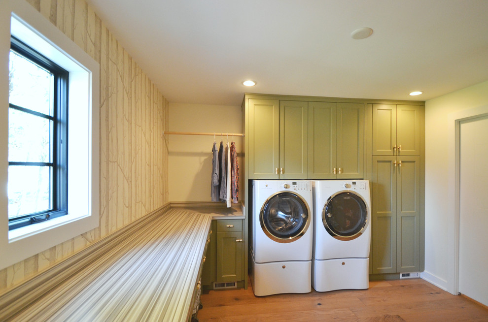 インディアナポリスにある高級な中くらいなモダンスタイルのおしゃれな洗濯室 (L型、落し込みパネル扉のキャビネット、緑のキャビネット、白い壁、淡色無垢フローリング、左右配置の洗濯機・乾燥機) の写真