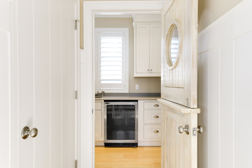 Nautical utility room in Other with a built-in sink, shaker cabinets, white cabinets, engineered stone countertops, beige walls and light hardwood flooring.