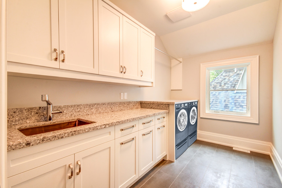 Photo of a large contemporary single-wall separated utility room in Toronto with a submerged sink, shaker cabinets, white cabinets, terrazzo worktops, grey walls, ceramic flooring and a side by side washer and dryer.