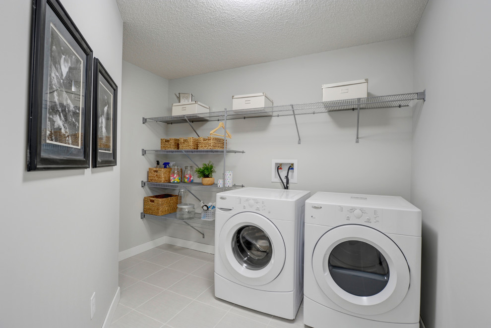 Einzeilige, Mittelgroße Klassische Waschküche mit weißer Wandfarbe, Keramikboden und Waschmaschine und Trockner nebeneinander in Edmonton