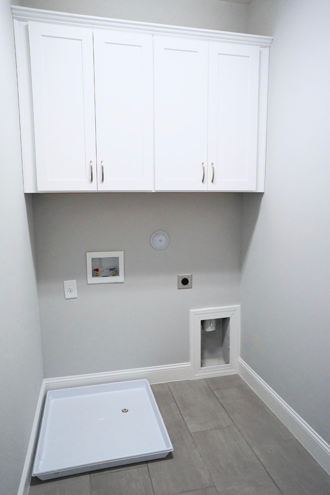 Ispirazione per una piccola sala lavanderia design con ante con riquadro incassato, ante bianche, pareti grigie, pavimento con piastrelle in ceramica e lavatrice e asciugatrice affiancate