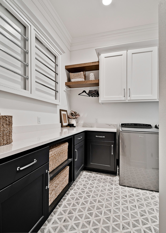 Inspiration för stora amerikanska parallella vitt tvättstugor enbart för tvätt, med en undermonterad diskho, luckor med upphöjd panel, vita skåp, bänkskiva i kvartsit, vitt stänkskydd, vita väggar, klinkergolv i porslin, en tvättmaskin och torktumlare bredvid varandra och grått golv