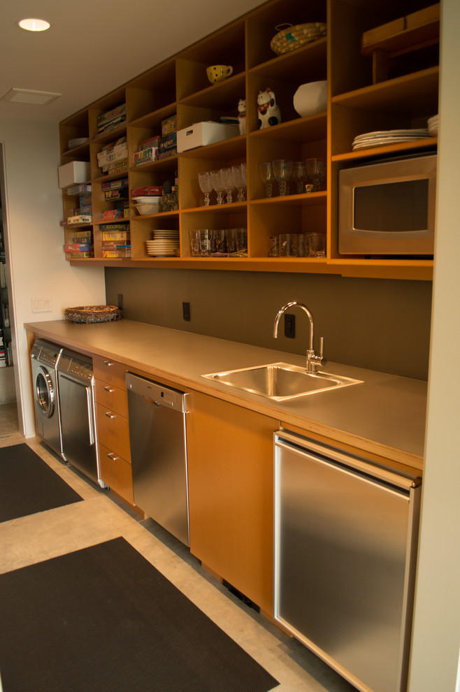 Utility room - mid-sized modern galley concrete floor utility room idea in Portland with a drop-in sink, flat-panel cabinets, light wood cabinets, laminate countertops, gray walls and a side-by-side washer/dryer