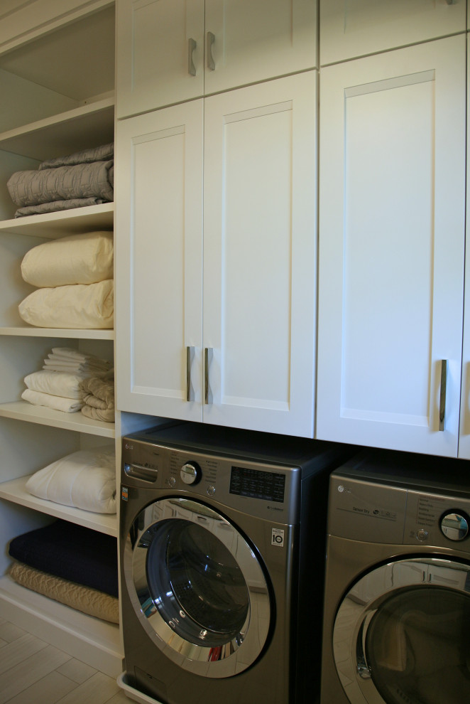 ミルウォーキーにある高級な中くらいなトランジショナルスタイルのおしゃれな洗濯室 (ll型、フラットパネル扉のキャビネット、白いキャビネット、珪岩カウンター、白いキッチンパネル、セラミックタイルのキッチンパネル、緑の壁、セラミックタイルの床、左右配置の洗濯機・乾燥機、ベージュの床、緑のキッチンカウンター) の写真