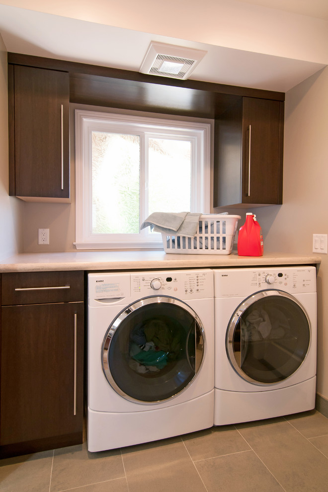 Laundry room - contemporary limestone floor laundry room idea in San Francisco with flat-panel cabinets, dark wood cabinets, quartz countertops and a side-by-side washer/dryer