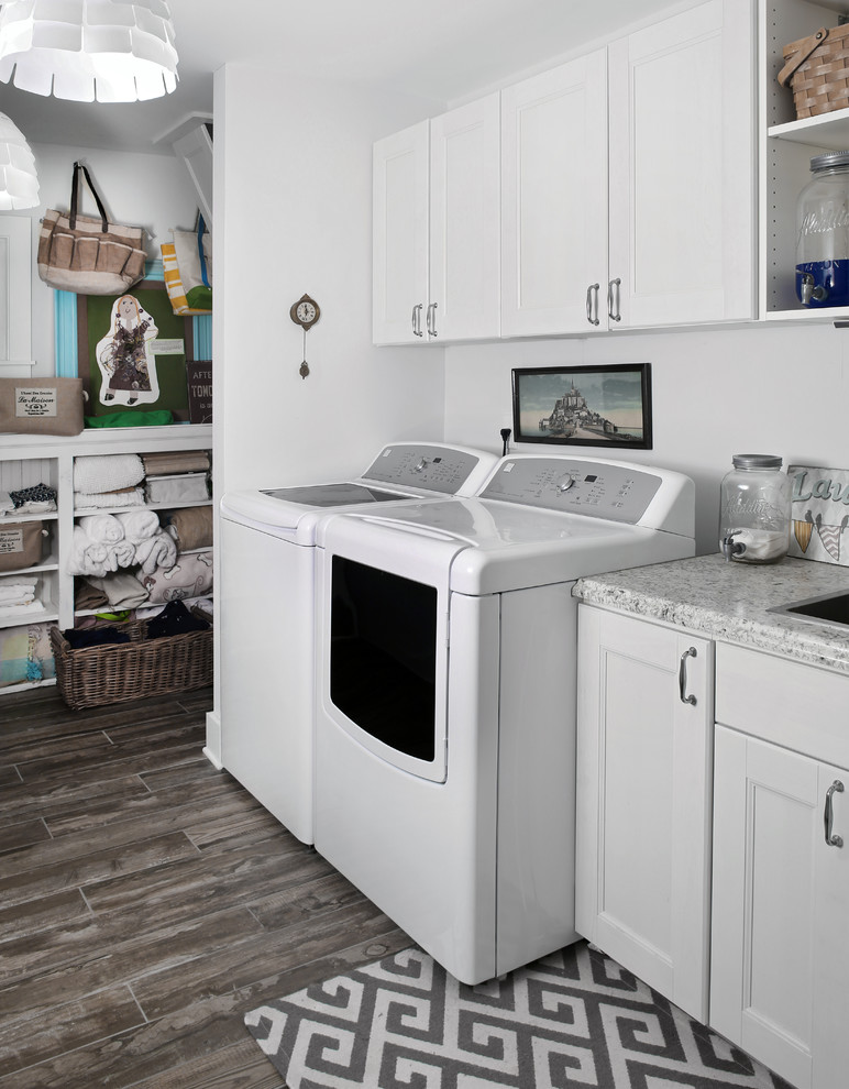 Design ideas for a traditional laundry cupboard in Jacksonville with white cabinets, white walls, porcelain flooring and a side by side washer and dryer.