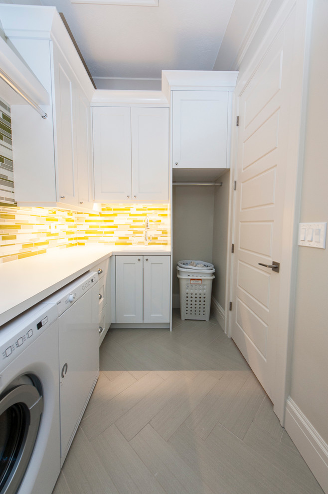 Medium sized scandi l-shaped separated utility room in Salt Lake City with shaker cabinets, white cabinets, laminate countertops, white walls, porcelain flooring, a side by side washer and dryer and grey floors.