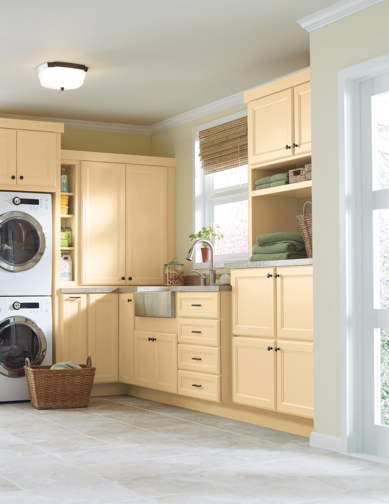 Idéer för en mellanstor klassisk l-formad tvättstuga enbart för tvätt, med luckor med infälld panel, gula skåp, bänkskiva i koppar, gula väggar, klinkergolv i keramik och en tvättpelare
