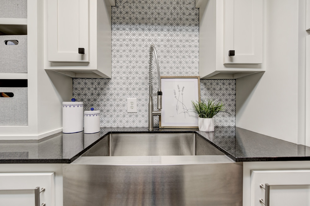 Inspiration for a medium sized traditional galley separated utility room in Oklahoma City with a belfast sink, shaker cabinets, white cabinets, granite worktops, grey walls, medium hardwood flooring, a side by side washer and dryer, brown floors and black worktops.