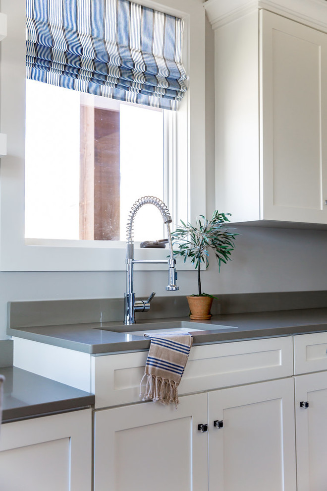 Immagine di una lavanderia classica di medie dimensioni con lavello sottopiano, ante in stile shaker, ante bianche, pareti grigie e top grigio