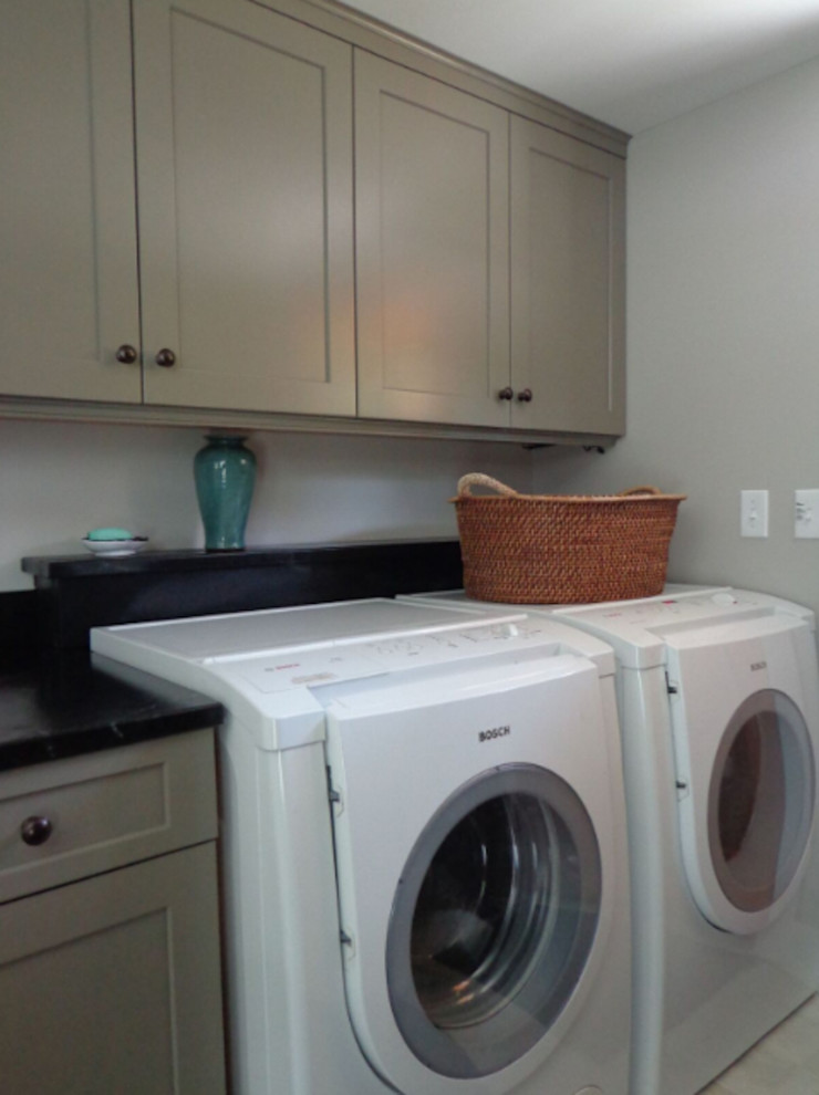 Example of a mid-sized classic single-wall beige floor utility room design in Burlington with shaker cabinets, gray cabinets, white walls and a side-by-side washer/dryer