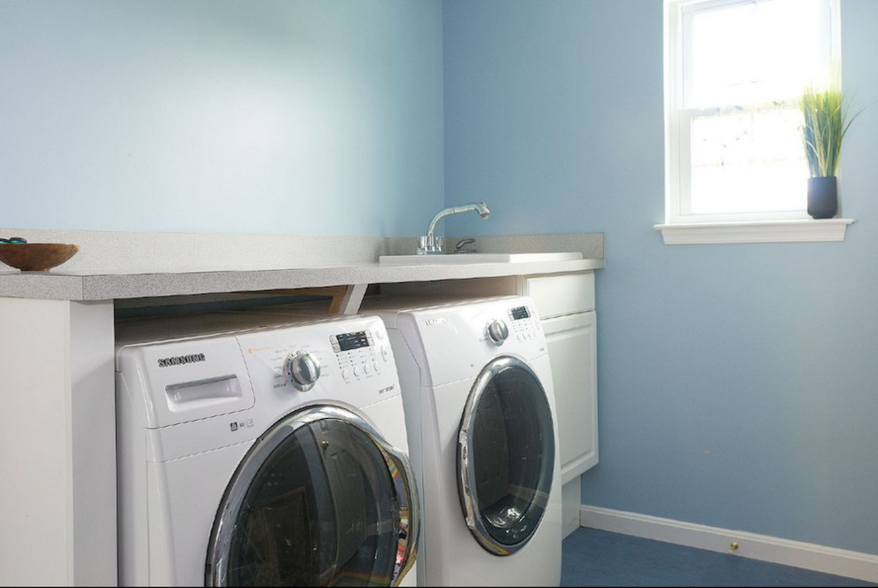 Esempio di una sala lavanderia chic di medie dimensioni con lavello da incasso, top in superficie solida, pareti blu, pavimento in pietra calcarea e lavatrice e asciugatrice affiancate