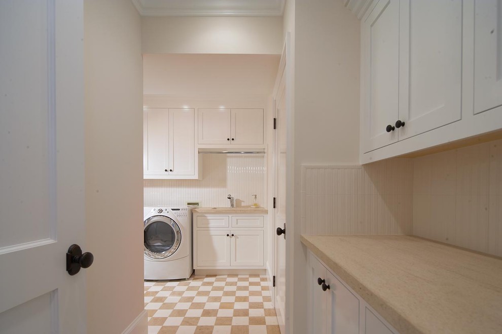Exempel på en klassisk tvättstuga, med vita skåp och flerfärgat golv