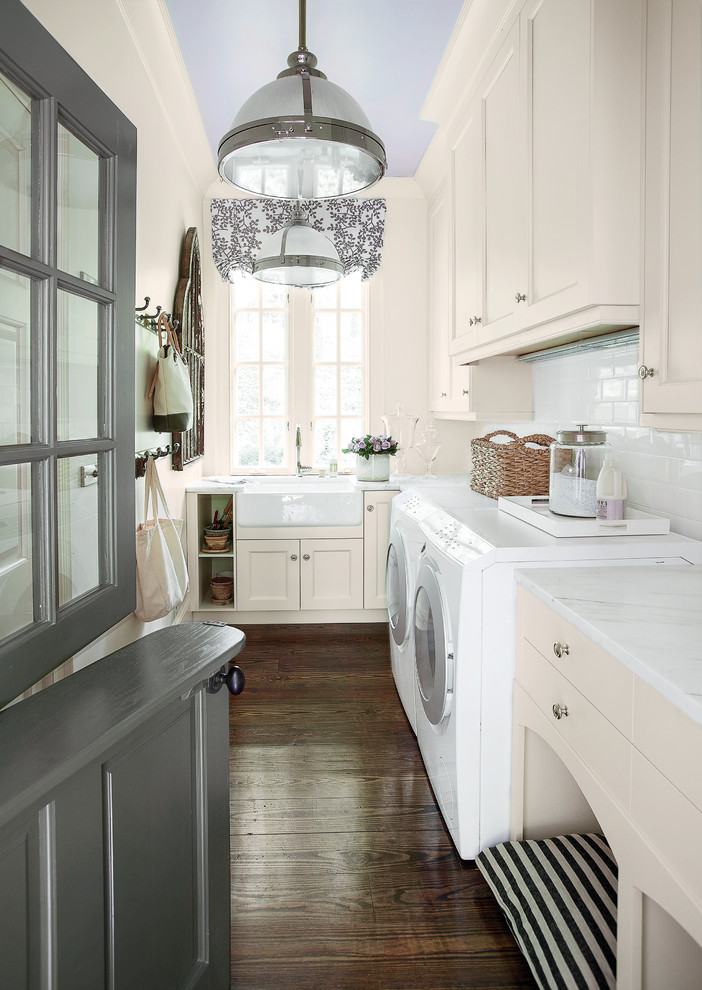 Elegant brown floor laundry room photo in Atlanta with beige cabinets, a farmhouse sink and white countertops