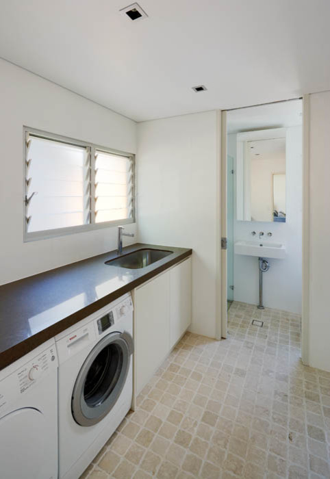 Idee per una grande sala lavanderia stile marinaro con lavello sottopiano, ante lisce, ante bianche, pareti bianche e lavatrice e asciugatrice affiancate