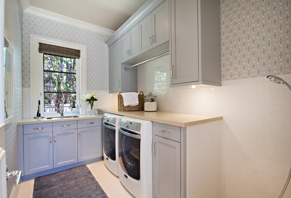 This is an example of a large classic l-shaped utility room in Miami with a submerged sink, shaker cabinets, grey cabinets and a side by side washer and dryer.