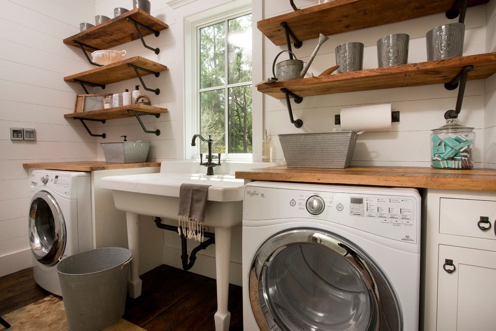 Inspiration för mellanstora klassiska linjära tvättstugor enbart för tvätt, med öppna hyllor, skåp i mellenmörkt trä, träbänkskiva, vita väggar, mörkt trägolv och en tvättmaskin och torktumlare bredvid varandra